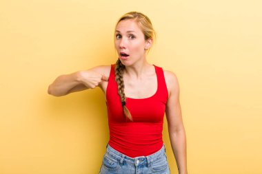 Genç sarışın kadın şaşkın, şaşkın ve güvensiz hissediyor, kendini göstererek kim olduğunu soruyor, ben mi??