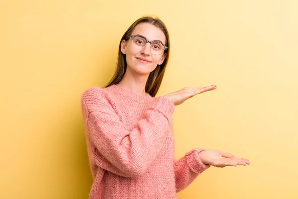 年轻的漂亮的成年女子 双手都握在旁边的复制空间上 提供或宣传一件物品 — 图库照片