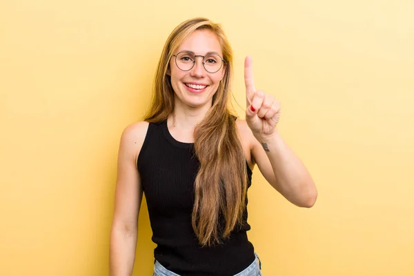 Young Adult Blonde Woman Smiling Looking Friendly Showing Number One — Foto Stock