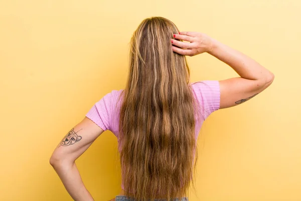 Young Adult Blonde Woman Thinking Doubting Scratching Head Feeling Puzzled — Stockfoto