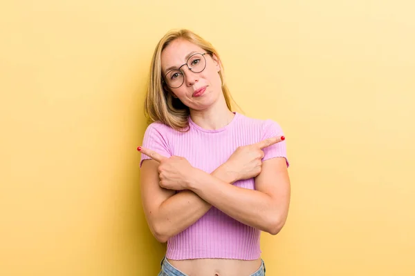 Young Adult Blonde Woman Looking Puzzled Confused Insecure Pointing Directions — Stockfoto
