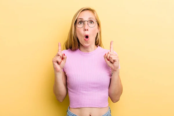 Young Adult Blonde Woman Feeling Awed Open Mouthed Pointing Upwards — Stockfoto