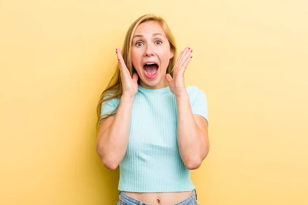 Νεαρή Ενήλικη Ξανθιά Γυναίκα Αισθάνεται Σοκαρισμένη Και Ενθουσιασμένη Γελώντας Έκπληκτη — Φωτογραφία Αρχείου