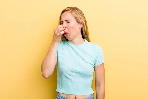 Young Adult Blonde Woman Feeling Disgusted Holding Nose Avoid Smelling — Stockfoto