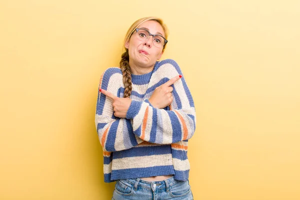 Young Adult Blonde Woman Looking Puzzled Confused Insecure Pointing Directions — Stockfoto