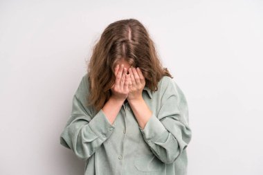 teenager young girl feeling sad, frustrated, nervous and depressed, covering face with both hands, crying