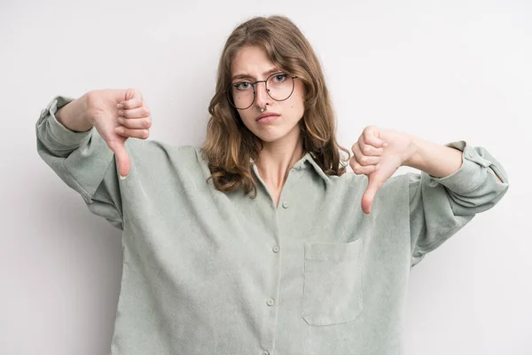 teenager young girl looking sad, disappointed or angry, showing thumbs down in disagreement, feeling frustrated