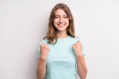 teenager young girl shouting triumphantly, laughing and feeling happy and excited while celebrating success