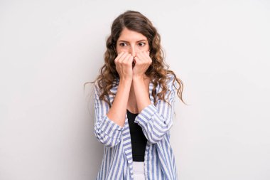 Genç ve güzel bir kadın endişeli, gergin, stresli ve korkmuş görünüyor. Tırnaklarını yiyor ve yanal fotokopi alanı arıyor.