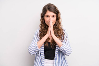 Genç ve güzel bir kadın endişeli, umutlu ve dindar hissediyor, sadık bir şekilde avuç içiyle dua ediyor, af diliyor.