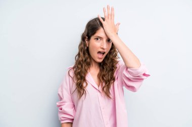 young adult pretty woman raising palm to forehead thinking oops, after making a stupid mistake or remembering, feeling dumb