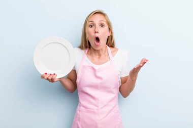 Sarışın, genç, yetişkin bir kadın elinde boş bir tabak tutuyor. Şef konsepti