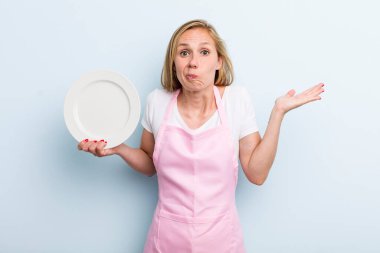 pretty blonde woman with an empty dish. chef concept