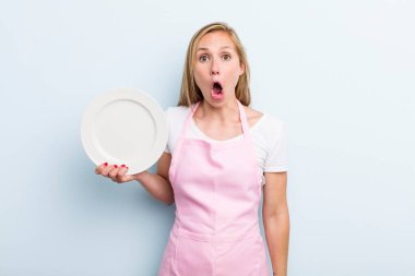 pretty blonde woman with an empty dish. chef concept