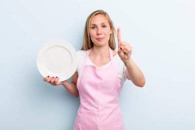 pretty blonde woman with an empty dish. chef concept