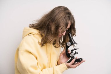 young girl scients student with a microscope