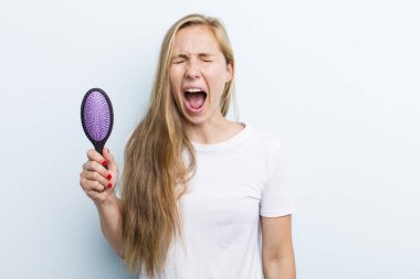 Sarışın, güzel kadın. Bir saç tarağıyla