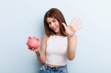 young adult pretty woman with a piggy bank