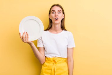 Genç ve güzel bir kadın şef ve boş bir tabak.