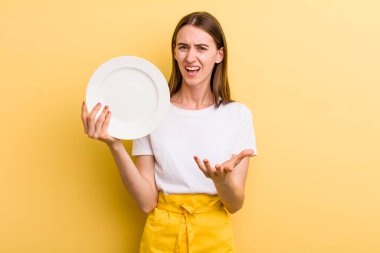 Genç ve güzel bir kadın şef ve boş bir tabak.