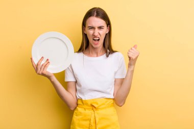 Genç ve güzel bir kadın şef ve boş bir tabak.