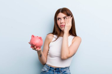 young adult pretty woman with a piggy bank. savings concept