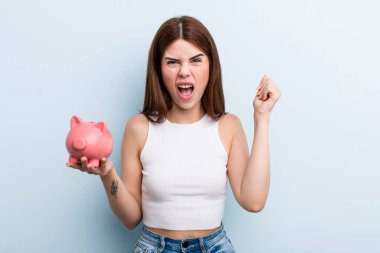 young adult pretty woman with a piggy bank. savings concept