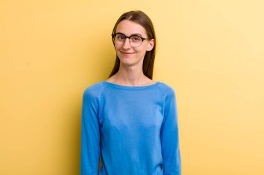 Sarı duvara yaslanmış genç ve güzel bir kadın.