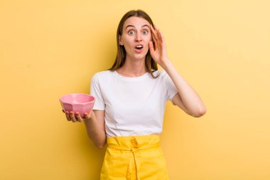 Genç, yetişkin, güzel aşçı kadın boş bir kaseyle