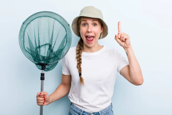 young adult blonde fisher woman with a net. holidays and hobbie concept