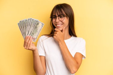 hispanic woman pointing at camera choosing you. dollar banknotes concept