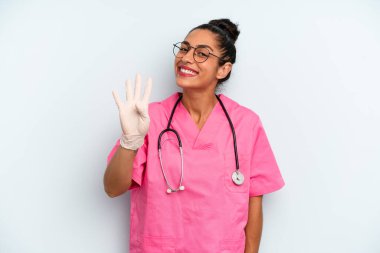 İspanyol kadın gülümsüyor ve arkadaş canlısı görünüyor, dört numarayı gösteriyor. hemşire konsepti