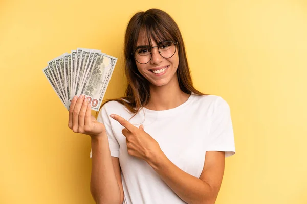 Hispanic Woman Smiling Cheerfully Feeling Happy Pointing Side Dollar Banknotes — 스톡 사진