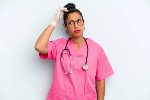 ヒスパニックな女は困惑して混乱して頭を掻いてる 看護師の概念 — ストック写真