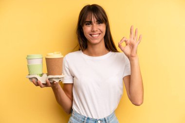 feeling happy, showing approval with okay gesture. take away coffees