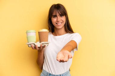 smiling happily with friendly and  offering and showing a concept. take away coffees