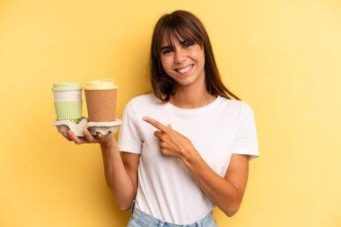 smiling cheerfully, feeling happy and pointing to the side. take away coffees