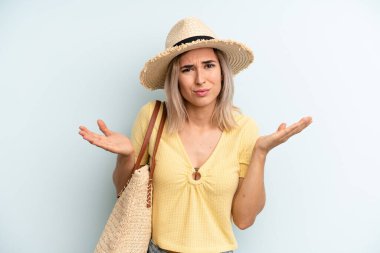 blonde woman feeling puzzled and confused and doubting. summer concept