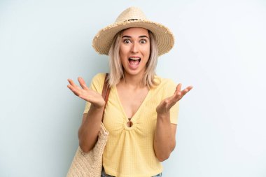 blonde woman feeling happy and astonished at something unbelievable. summer concept