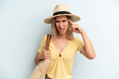blonde woman feeling confused and puzzled, showing you are insane. summer concept