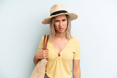 blonde woman feeling puzzled and confused. summer concept
