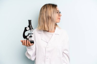 Profil bakışlı sarışın kadın hayal mi kuruyor yoksa hayal mi kuruyor? Bilim adamı öğrenci konsepti