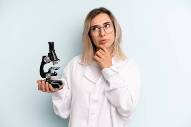 Sarışın kadın düşünüyor, kuşkulu ve şaşkın hissediyor. Bilim adamı öğrenci konsepti