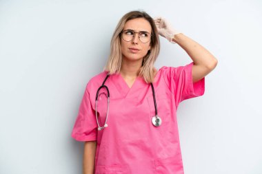 Kafası karışmış, kafası karışmış, kaşınan sarışın bir kadın. hemşire konsepti