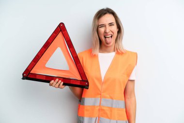 Sarışın, güzel, neşeli ve asi tavırlı, şaka yapan ve dilini dışarı çıkaran bir kadın. araba acil konsepti