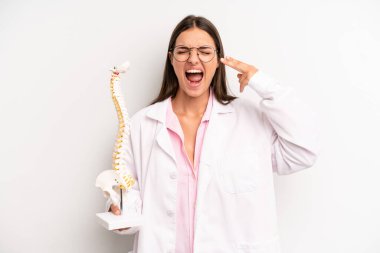 Güzel bir kadın mutsuz ve stresli görünüyor, intihar jesti silah işareti yapıyor. Omurga uzmanı konsepti