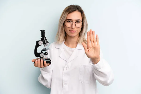 Blonde Woman Looking Serious Showing Open Palm Making Stop Gesture — Stockfoto