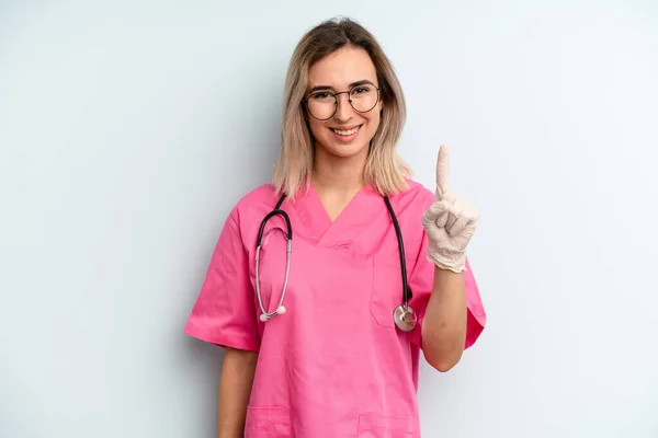 Blonde Woman Smiling Looking Friendly Showing Number One Nurse Concept — 图库照片