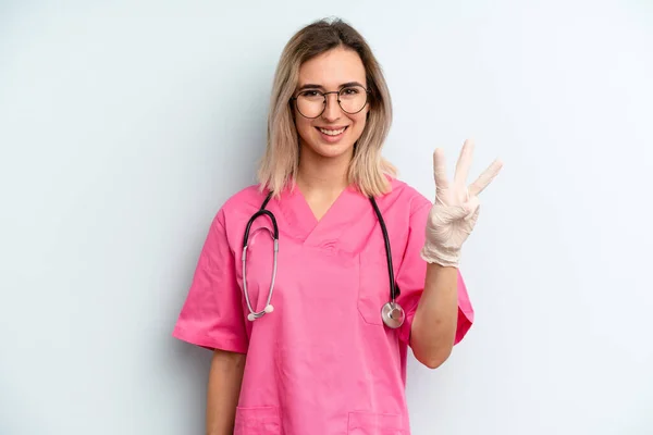 Blonde Woman Smiling Looking Friendly Showing Number Three Nurse Concept — Stock fotografie
