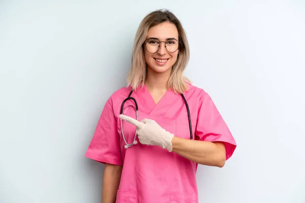 Blonde Woman Smiling Cheerfully Feeling Happy Pointing Side Nurse Concept — Stockfoto